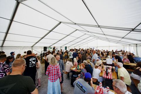 The marquee packed with guests at long tables.